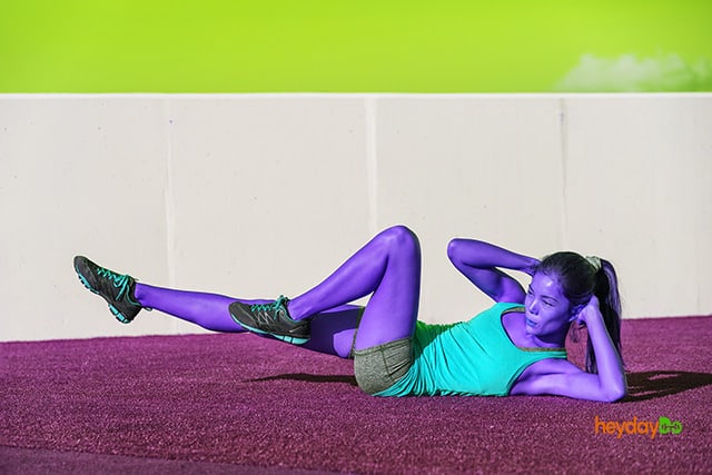 Young woman doing bicycle crunches as an ab exercise